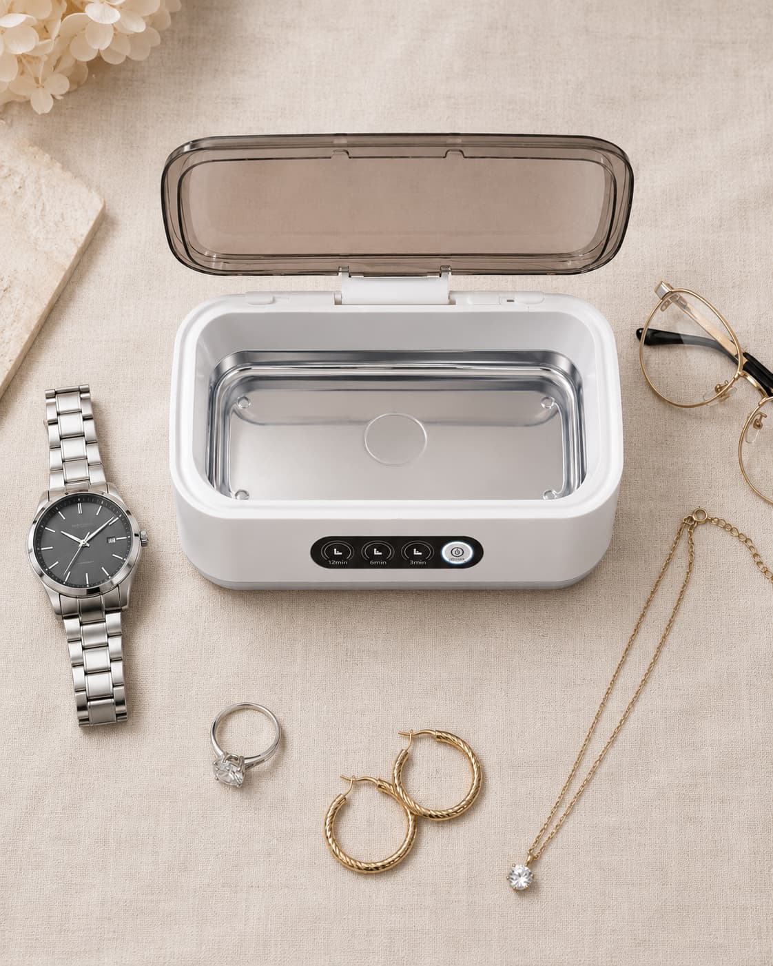 Aurelle Sparkle Bath surrounded by a watch, ring, gold hoop earrings, and a diamond necklace it can clean