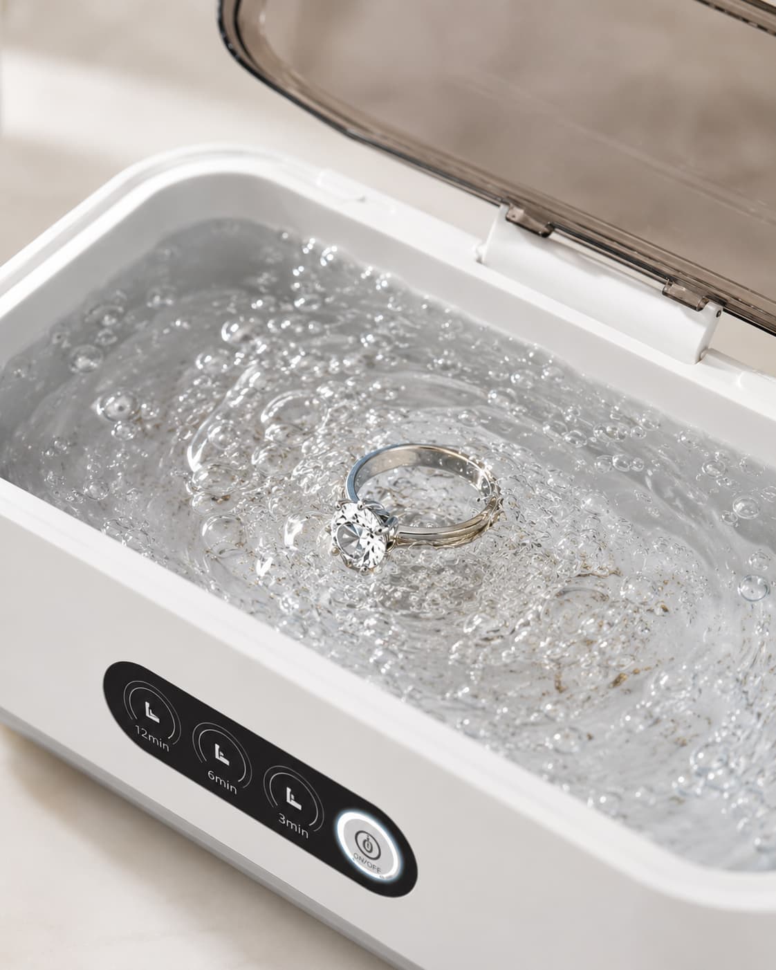 Diamond ring being cleaned inside the Aurelle Sparkle Bath with bubbling ultrasonic water and timer controls